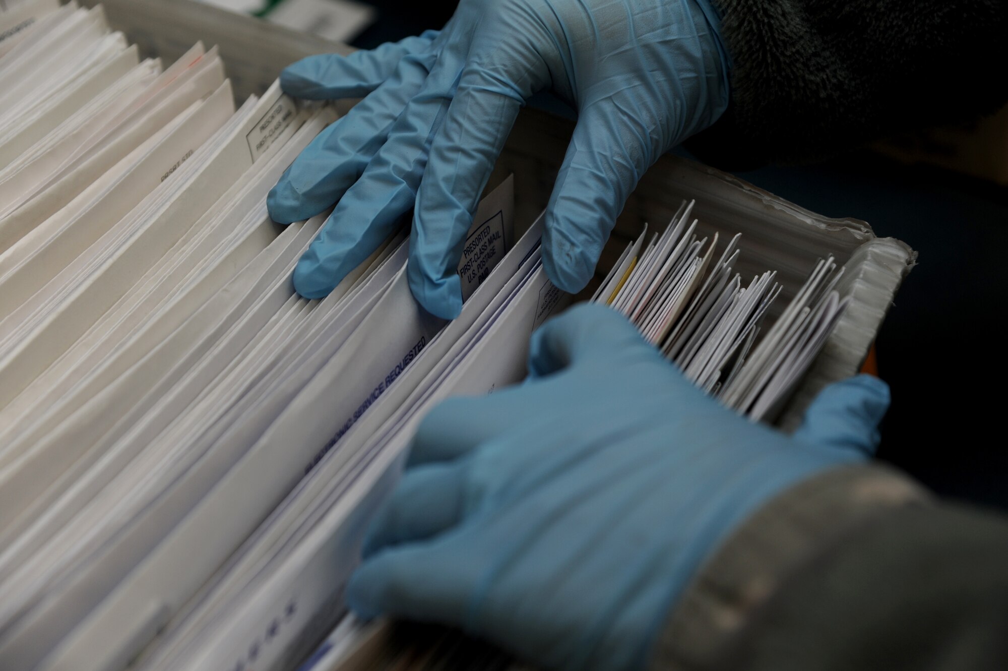 An Airman sorts through junk mail with latex gloves Jan. 12, 2015, at Little Rock Air Force Base, Ark. Airmen wear personal protective equipment as a precaution to protect themselves from potentially suspicious mail. (U.S. Air Force photo by Airman 1st Class Mercedes Muro)