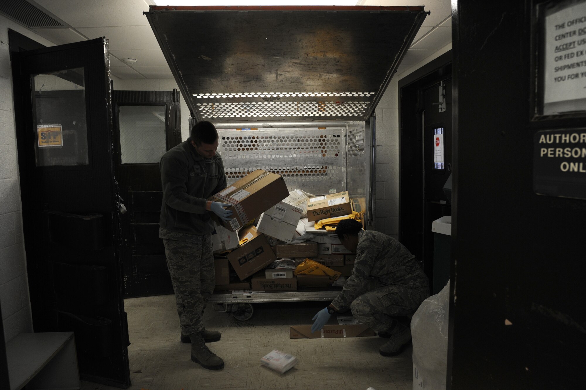 Airmen sort packages from a mail cart Jan. 12, 2014, at Little Rock Air Force Base, Ark. Airmen process all incoming packages and mail before it is delivered to the base populous. (U.S. Air Force photo by Airman 1st Class Mercedes Muro)