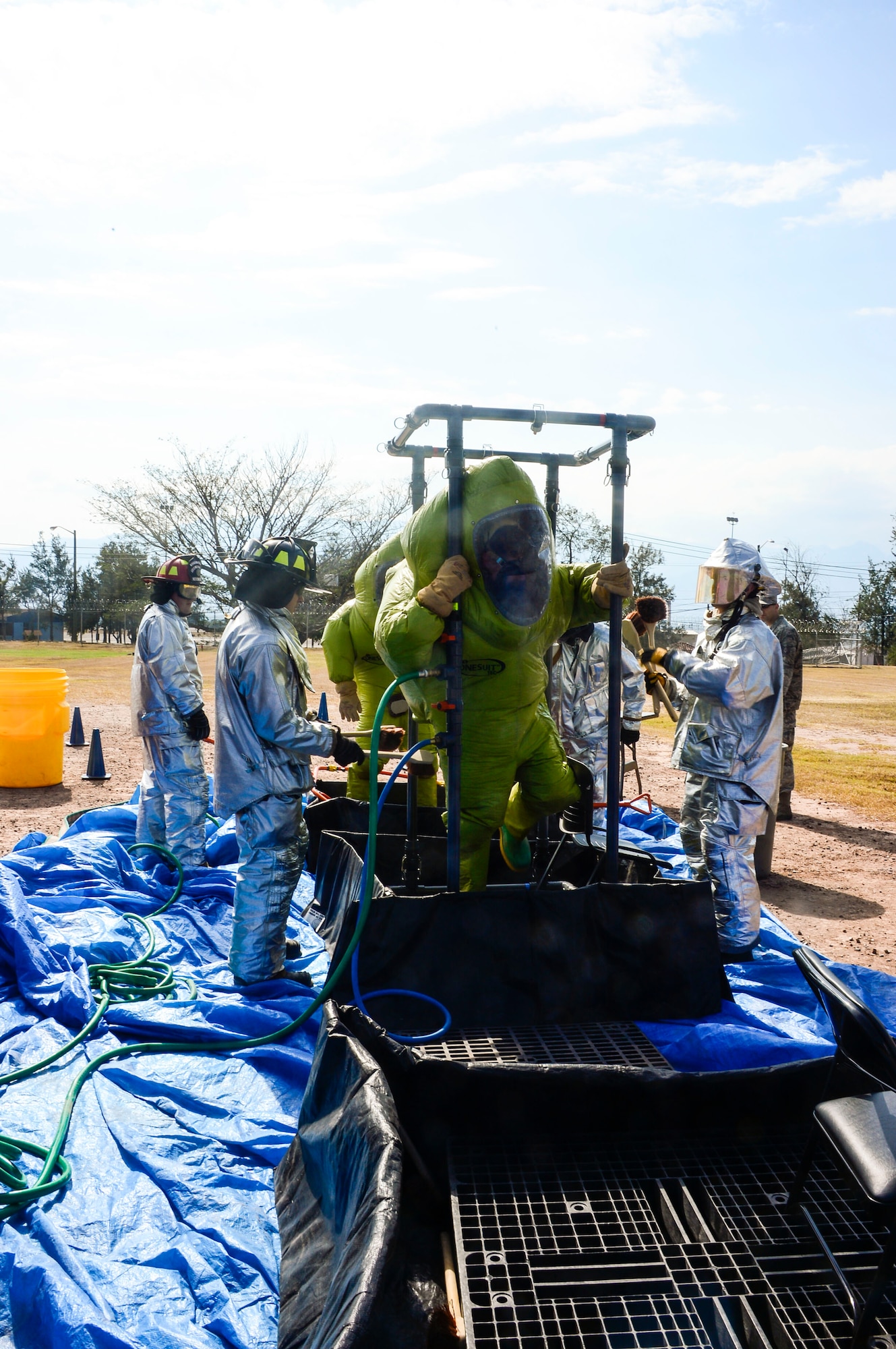 U.S. Air Force Airman 1st Classes Gregory Pease and Nolan Bailey, 612th Air Base Squadron firefighters, walk through a decontamination line during a hazardous material exercise on Soto Cano Air Base, Honduras, Feb. 10, 2015. The training exercise was held to guarantee members assigned to the 612th ABS Fire Department are compliant with the Department of Defense’s requirement that all Air Force firefighters are certified to the hazmat technical level. (U.S. Air Force photo/Tech. Sgt. Heather Redman)