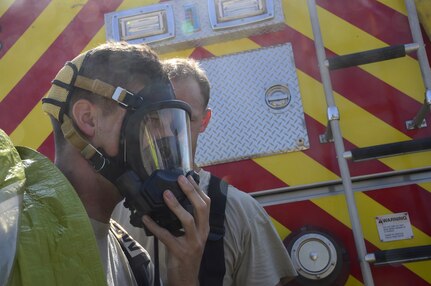 U.S. Air Force Staff Sgt. Daniel Easterlund, 612th Air Base Squadron firefighter, helps U.S. Air Force Airman 1st Class Gregory Pease, 612th Air Base Squadron firefighter, don a contamination suit during a hazardous material exercise on Soto Cano Air Base, Honduras, Feb. 10, 2015. The training exercise was held to guarantee members assigned to the 612th ABS Fire Department are compliant with the Department of Defense’s requirement that all Air Force firefighters are certified to the hazmat technical level. (U.S. Air Force photo/Tech. Sgt. Heather Redman)