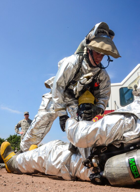 U.S. Air Force Airman 1st Class Gregory Pease, 612th Air Base Squadron firefighter, provides simulated medical attention to U.S. Air Force Senior Airman Collin Lorash, 612th Air Base Squadron firefighter, during a hazardous material exercise on Soto Cano Air Base, Honduras, Feb. 10, 2015. The training exercise was held to guarantee members assigned to the 612th ABS Fire Department are compliant with the Department of Defense’s requirement that all Air Force firefighters are certified to the hazmat technical level. (U.S. Air Force photo/Tech. Sgt. Heather Redman)