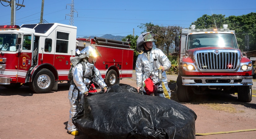 U.S. Air Force Airman 1st Class Adrianna Hopkins and U.S. Air Force Staff Sgt. Daniel Easterlund, 612th Air Base Squadron firefighters, set up a decontamination bath during a hazardous material exercise on Soto Cano Air Base, Honduras, Feb. 10, 2015. The training exercise was held to guarantee members assigned to the 612th ABS Fire Department are compliant with the Department of Defense’s requirement that all Air Force firefighters are certified to the hazmat technical level. (U.S. Air Force photo/Tech. Sgt. Heather Redman)