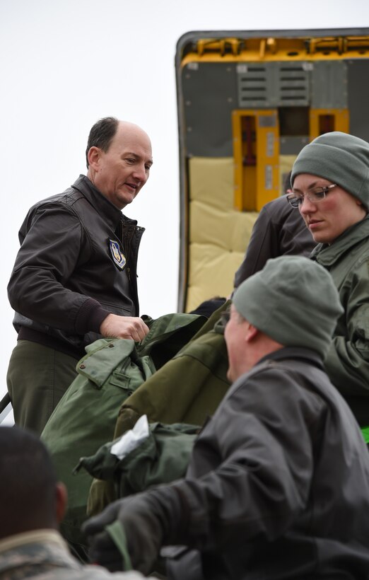 Col. Thomas K. Smith, 459th Air Refueling Wing commander, passes bags from the KC-135 Stratotanker to other unit members on the flightline at Joint Base Andrews, Md., Feb. 9, 2015. It is common for unit members to unload bags while returnees embrace family. (U.S. Air Force photo/Airman 1st Class Philip Bryant)