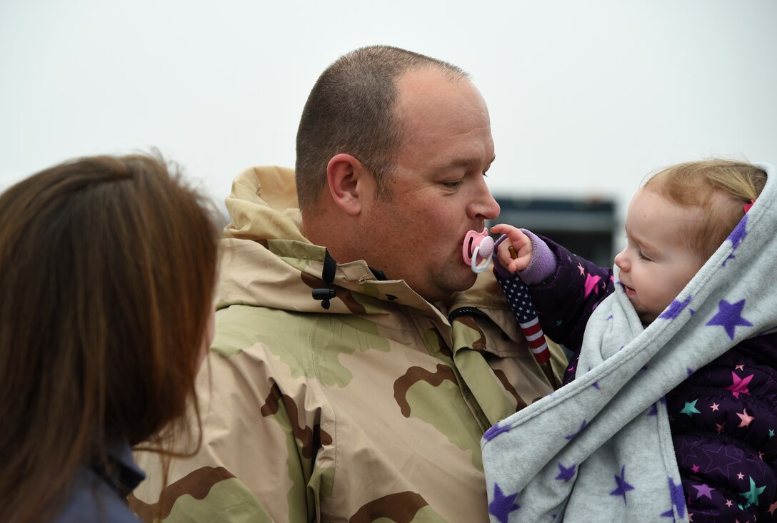 Maj. Stephen Akins, 756th Air Refueling Squadron KC-135 Stratotanker aircraft commander and pilot, holds his daughter on the flightine at Joint Base Andrews, Md., Feb. 9, 2015. The Akins family reunited after a two month deployment to the 379th Air Expeditionary Wing. (U.S. Air Force photo/Airman 1st Class Philip Bryant)