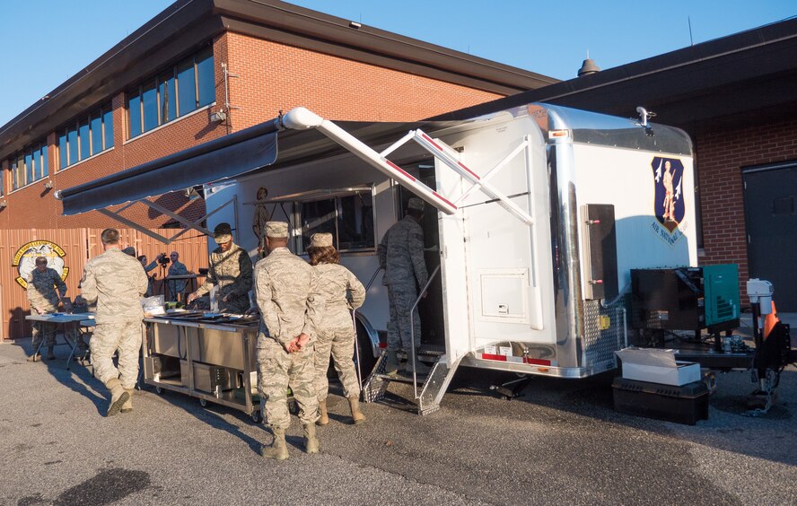 The 116th Services Flight, Georgia Air National Guard, serves a hot meal to E-8C Joint STARS aircraft maintainers during drill weekend at Robins Air Force Base, Ga., Feb. 7, 2015. The food service professionals from the 116th Air Control Wing took advantage of the opportunity to perform additional training on the use of their disaster relief mobile kitchen trailer (DRMKT), while providing nightshift aircraft maintenance workers the chance to enjoy a hot meal just off the flightline. The free-standing mobile kitchen, acquired by the unit just over a year ago, is designed for fast setup and teardown and can be transported aboard a C-130 Hercules aircraft. Airmen train on the DRMKT regularly to maintain readiness required to respond to a contingency situation across the Southeast United States. (U.S. Air National Guard photo by Master Sgt. Roger Parsons/Released)