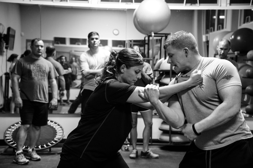 U.S. Air Force Staff Sgt. Dayne Tosi, Survival, Evasion, Resistance and Escape Specialist assigned to Joint Task Force-Bravo operations cell, and U.S. Air Force Master Sgt. Lyanna Pena-Lewis, JTF-Bravo communications superintendent, demonstrate techniques to escape your attacker during a self-defense class on Soto Cano Air Base, Honduras, Feb. 10, 2015.  The self-defense class was held to teach personnel assigned to JTF-Bravo about the importance of using self-defense to escape a violent situation. (U.S. Air Force photo/Tech. Sgt. Heather Redman)