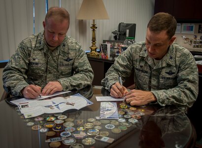 Col. Jeffrey DeVore, Joint Base Charleston commander, and Col. John Lamontagne, 437th Airlift Wing commander, sign their Air Force Assistance Fund contribution forms Feb. 10, 2015, at JB Charleston – Air Base, S.C. The AFAF is an annual effort to raise funds toward charitable affiliates that support Air Force families in the event of emergencies.   (U.S. Air Force photo / Senior Airman Tom Brading)