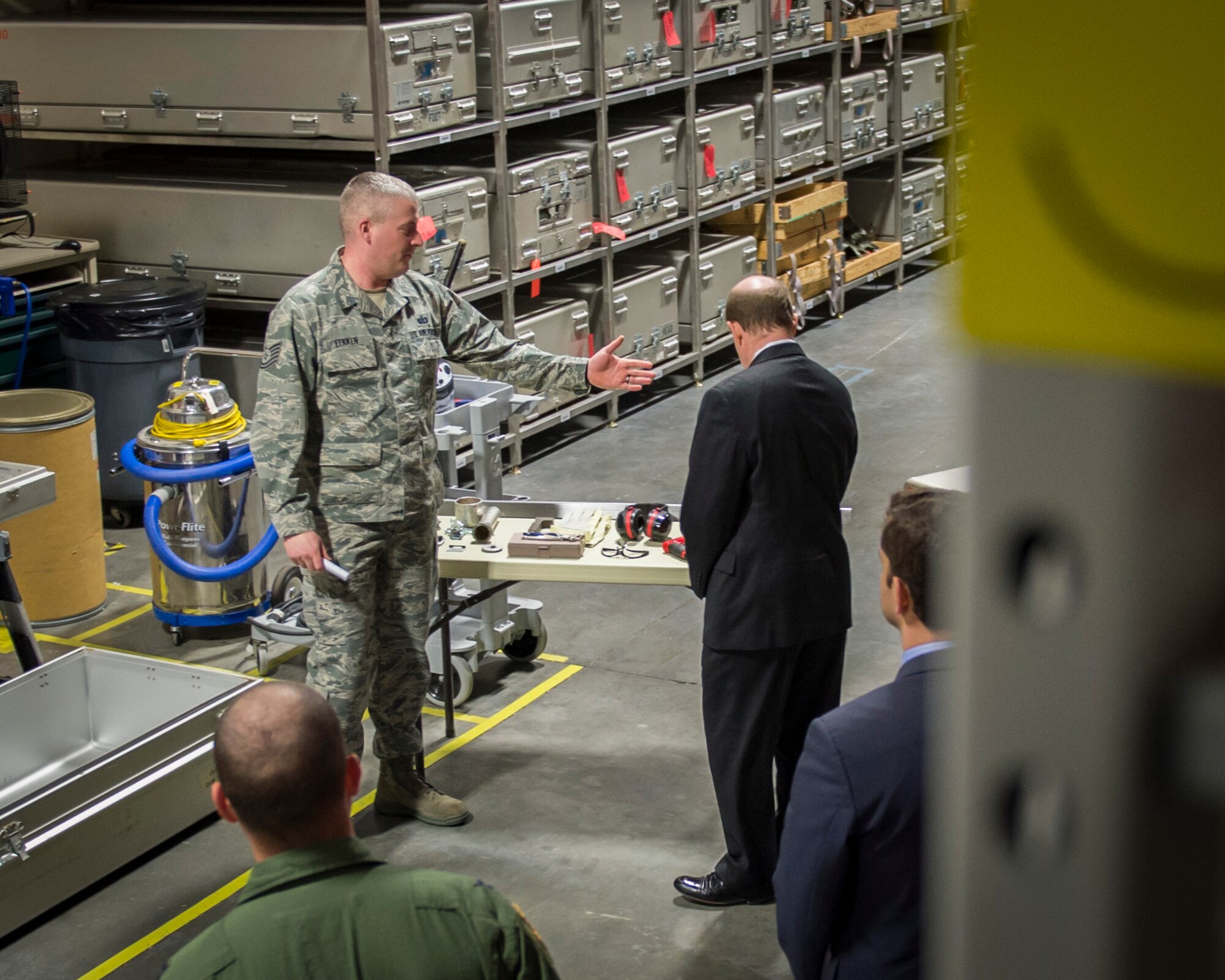 Tech. Sgt. Rob Fekken, Air Force Mortuary Affairs Operations facility manager, briefs Sen. Chris Coons of Delaware on the process of repairing human remains transfer cases Feb. 9, 2015, during the senator’s visit to Dover Air Force Base, Del. Fekken explained that AFMAO inspects and, if required, services every transfer case that comes to AFMAO before returning them to the field. (U.S. Air Force photo by Capt. Ray Geoffroy)
