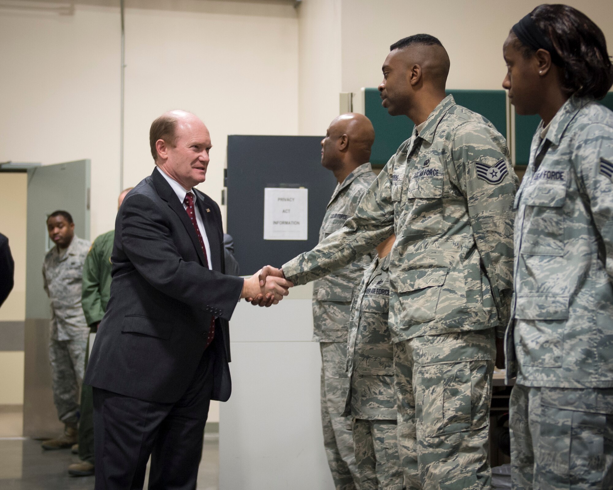Sen. Chris Coons of Delaware shakes hands with Staff Sgt. Garry Giddens, a services NCO assigned to the Air Force Mortuary Affairs Operations departures section Feb. 9, 2015, at Dover Air Force Base, Del., during a visit to the mortuary. The senator thanked AFMAO for its continued commitment to returning all fallen U.S. service members with dignity, honor and respect. (U.S. Air Force photo by Capt. Ray Geoffroy)