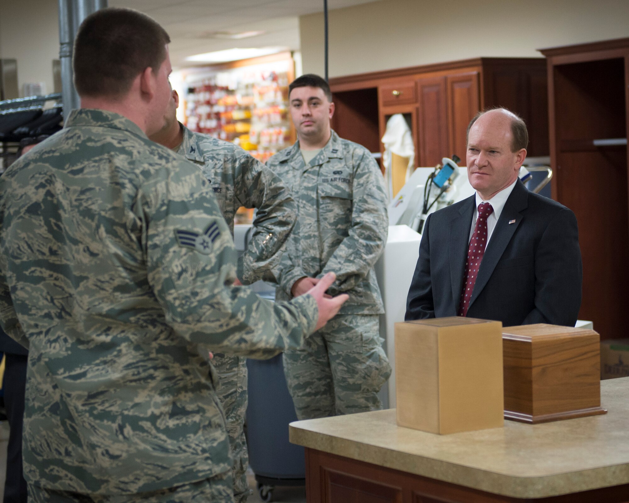 Senior Airman Nicholas Wavra, a services Airman assigned to the Air Force Mortuary Affairs Operations Dress and Restoration section, explains how he helps prepare uniforms for fallen warriors to Sen. Chris Coons of Delaware Feb. 9, 2015, during the senator’s visit to Dover Air Force Base, Del. Wavra and other AFMAO Airmen briefed Coons on the unique tasks performed at the Department of Defense’s sole port mortuary. (U.S. Air Force photo by Capt. Ray Geoffroy)