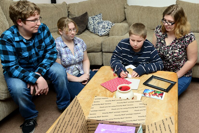 The children of U.S. Army Sgt. Justin Hughes, 510th Human Resource Company wheel vehicle mechanic, assemble a Valentine’s Day package at Fort Eustis, Va., Feb. 6, 2015. While deployed, Hughes’ family sends packages for each missed holiday. (U.S. Air Force photo by Senior Airman Kimberly Nagle/Released)