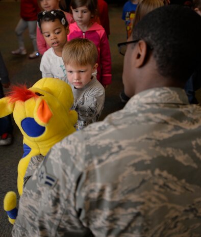 Airman 1st Class Ian McAdory, 628th Aerospace Medicine Squadron dental assistant, holds onto Dudley the Dinosaur while Aven Gravett practices brushing his teeth, Feb. 10, 2015 at the General Thomas R. Mikolajcik Child Development Center on Joint Base Charleston, S.C. In honor of Children’s Dental Month, the 628th Medical Group Dental Clinic educated more than 90 children on the importance of brushing their teeth and eating healthy snacks. Each child was given a dental goodie bag containing a toothbrush, toothpaste and a Mr. Tooth activity book. Gravett is the son of Tech. Sgt. Andrew Gravett, 437th Aircraft Maintenance Squadron. (U.S. Air Force photo / Trisha Gallaway)