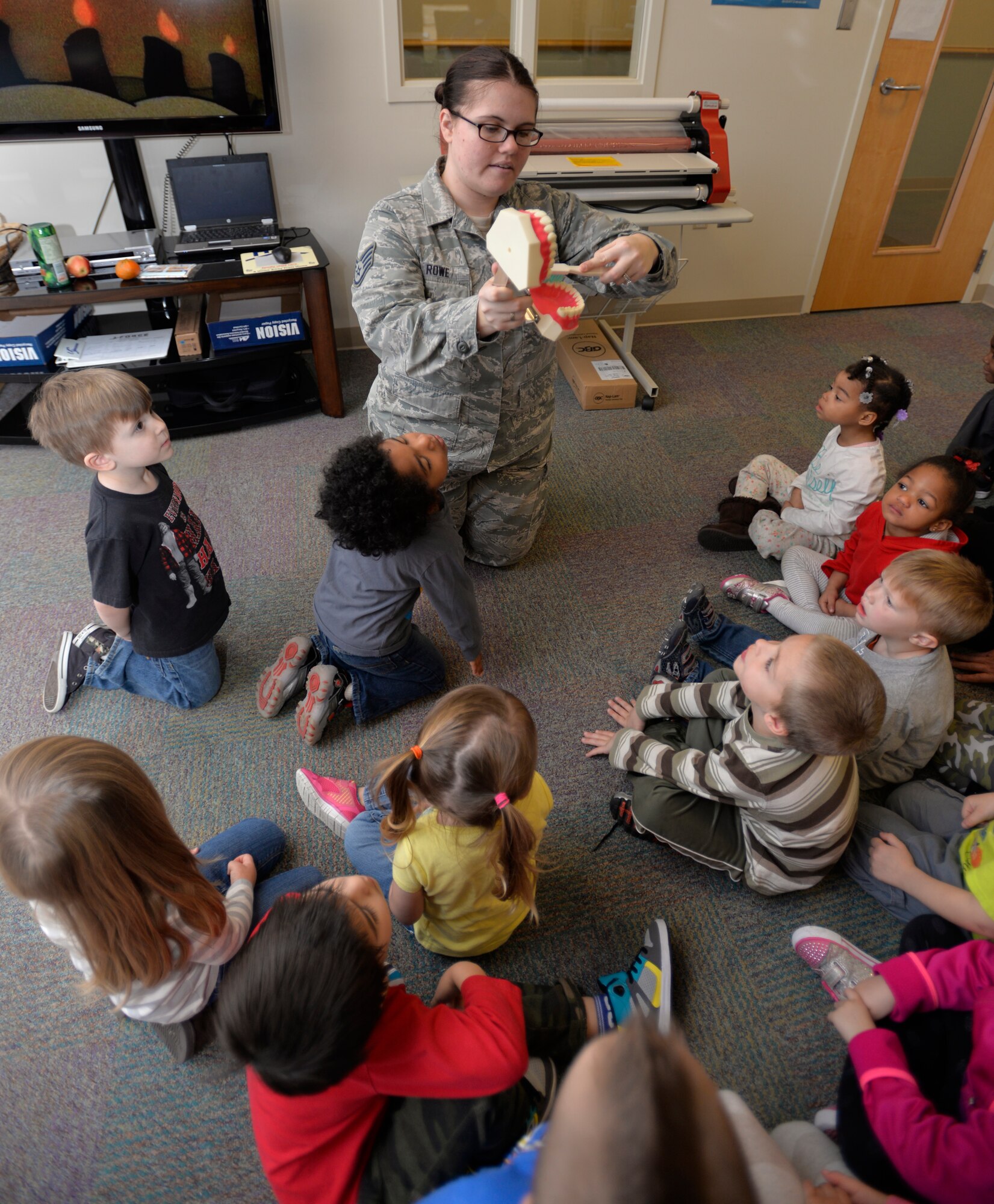 Staff Sgt. Stephanie Rowe, 628th Aerospace Medicine Squadron oral preventative specialist, shows a group of children how to properly brush their teeth, Feb. 10, 2015 at the General Thomas R. Mikolajcik Child Development Center on Joint Base Charleston, S.C. In honor of Children’s Dental Month, the 628th Medical Group Dental Clinic educated more than 90 children on the importance of brushing their teeth and eating healthy snacks. Each child was given a dental goodie bag containing a toothbrush, toothpaste and a Mr. Tooth activity book. (U.S. Air Force photo / Trisha Gallaway)