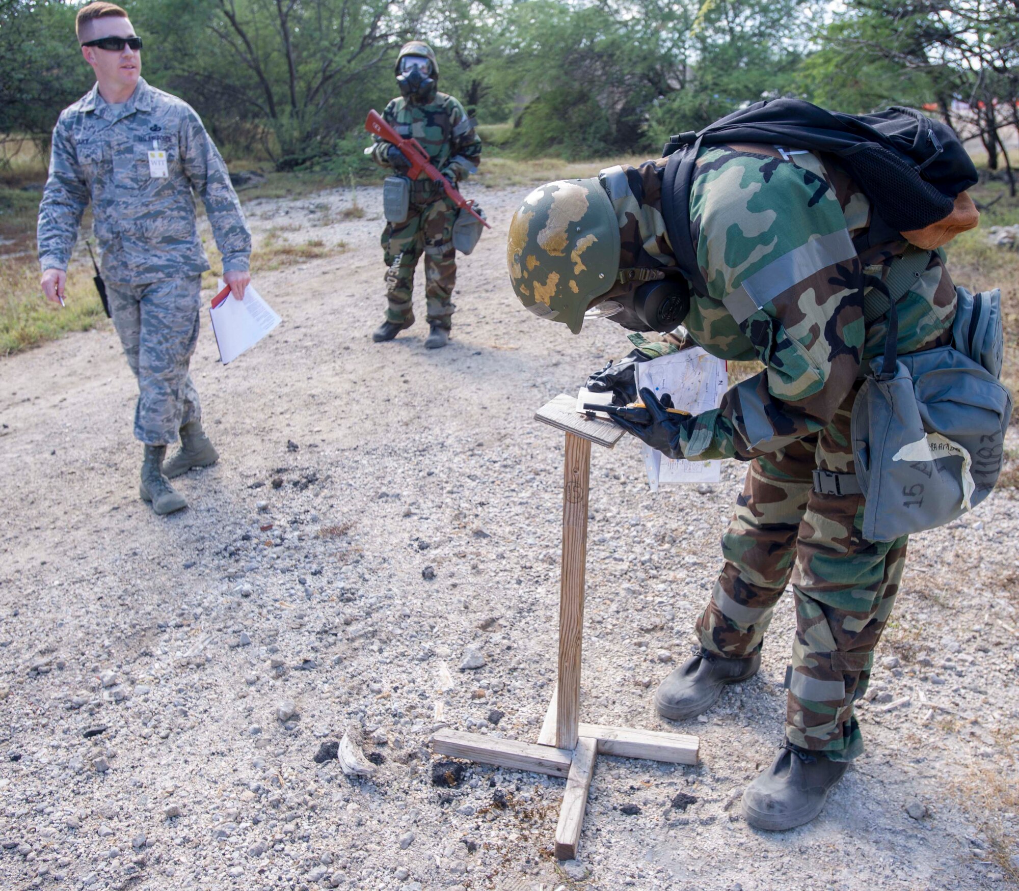Senior Airman Amber Acosta, 15th Comptroller Squadron financial services technician, checks M-8 paper to check for simulated contamination during a chemical, biological, radiation, nuclear and explosive exercise at Base X on Joint Base Pearl Harbor-Hickam, Hawaii, Feb. 6, 2015. The exercise tested the group’s ability to survive and operate in a hostile or chemical environment. (U.S. Air Force photo by Tech. Sgt. Terri Paden/RELEASED)