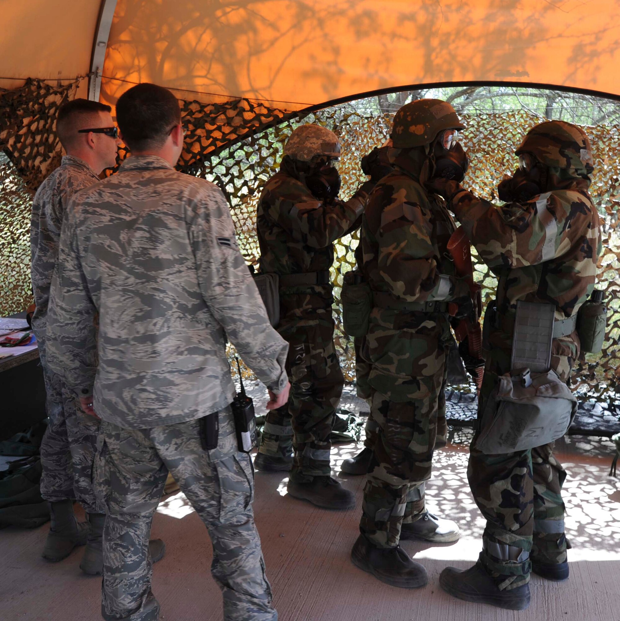 Members of the 15th Wing Staff Agencies perform a buddy check after donning Mission Oriented Protection Posture Four during a chemical, biological, radiation, nuclear and explosive exercise at Base X on Joint Base Pearl Harbor-Hickam, Hawaii, Feb. 6, 2015. The exercise tested the group’s ability to survive and operate in a hostile or chemical environment. (U.S. Air Force photo by Tech. Sgt. Terri Paden/RELEASED)