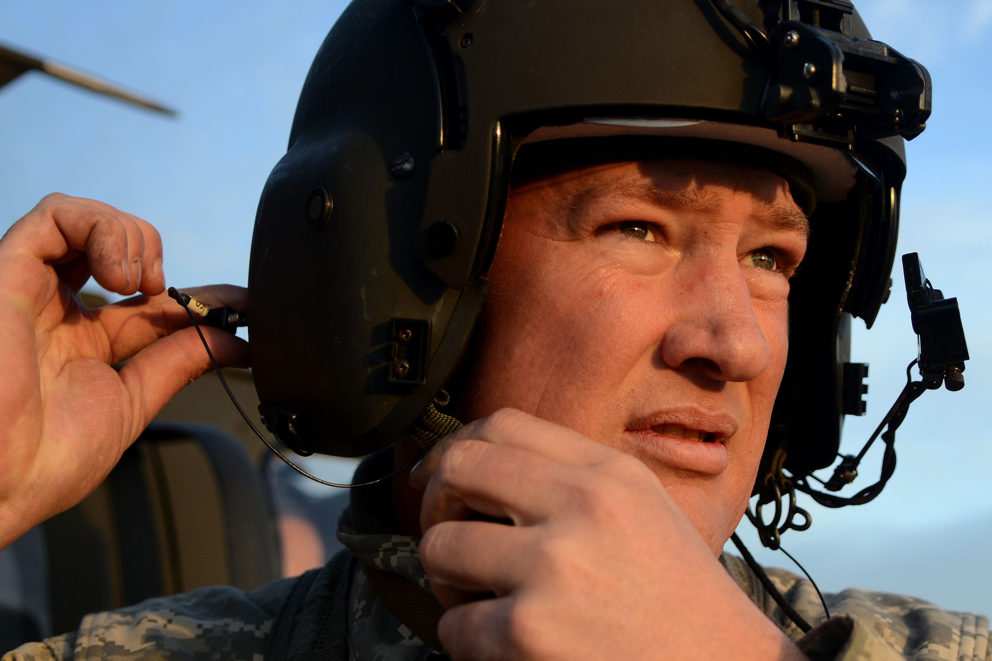 A U.S. Army National Guard soldier assigned to the 1st Battalion, 169th Aviation Regiment, Ft. Bragg, N.C., adjusts his flight helmet before takeoff at Poinsett Electronic Combat Range, Sumter, S.C., Feb. 6, 2015. While at Poinsett, soldiers practiced ground shooting on the M240 Machine Gun as well as day and night shooting from the air in a UH-60 Black Hawk. (U.S. Air Force photo by Airman 1st Class Michael Cossaboom/Released)