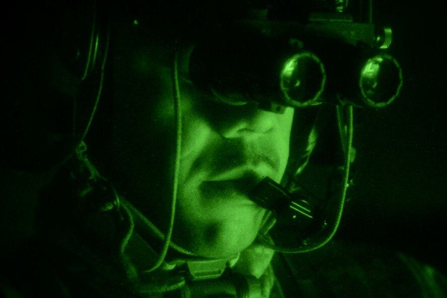 A U.S. Army National Guard soldier assigned to the 1st Battalion, 169th Aviation Regiment, Ft. Bragg, N.C., communicates with the pilot of a UH-60 Black Hawk before a night flight at Poinsett Electronic Combat Range, Sumter, S.C., Feb. 6, 2015. Poinsett Range is open to the public for viewing the aircraft as they train. (U.S. Air Force photo by Airman 1st Class Michael Cossaboom/Released)