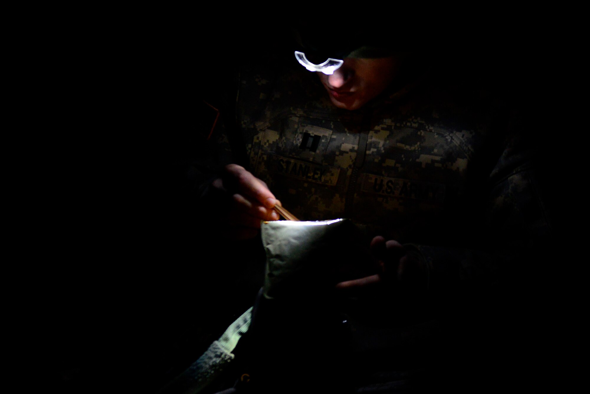 A U.S. Army National Guard soldier assigned to the 1st Battalion, 169th Aviation Regiment, Ft. Bragg, N.C., eats a meal-ready-to-eat at Poinsett Electronic Combat Range, Sumter, S.C., Feb. 6, 2015. The soldiers trained during the day as well as during the night to ensure they remain mission ready. (U.S. Air Force photo by Airman 1st Class Diana M. Cossaboom/Released)