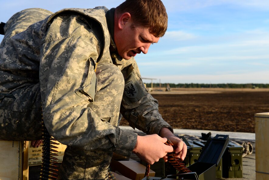 A U.S. Army National Guard soldier assigned to the 1st Battalion, 169th Aviation Regiment, Ft. Bragg, N.C., prepares the bullets for a M240 machine gun at Poinsett Electronic Combat Range, Sumter, S.C., Feb. 6, 2015. Military members can also utilize the electronic warfare capabilities offered at the range which shoots simulated munitions at the aircraft giving the pilots a safe environment to practice different scenarios. (U.S. Air Force photo by Airman 1st Class Diana M. Cossaboom/Released)