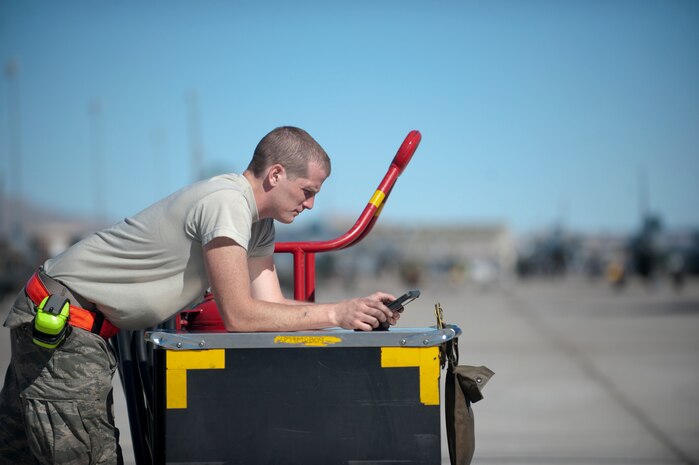 Airman 1st Class Aaron Hoffhines, a crew chief assigned to the 20th Aircraft Maintenance Squadron, Shaw Air Force Base, S.C., looks at tech data prior to a Red Flag 15-1 training sortie at Nellis Air Force Base, Nev., Feb. 10, 2015. Red Flag involves a variety of attack, fighter, bomber, reconnaissance, electronic warfare, airlift support and search and rescue aircraft. (U.S. Air Force photo by Staff Sgt. Siuta B. Ika)