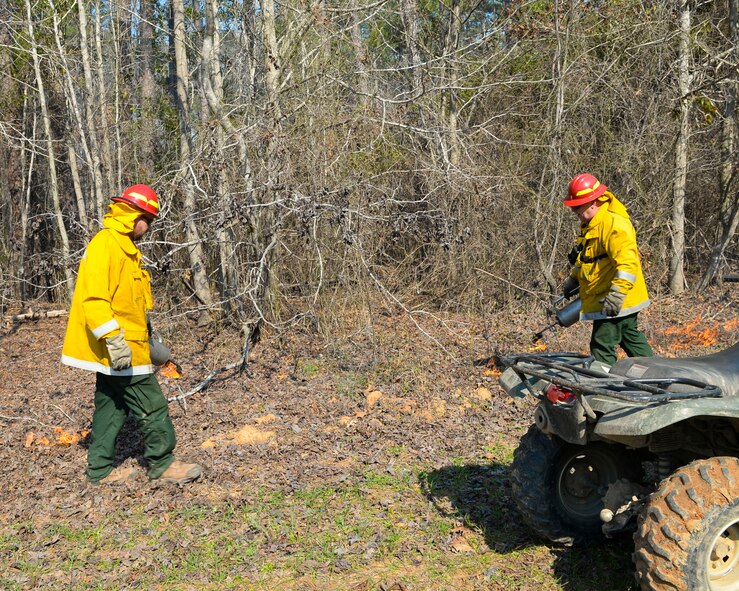 John Sherred, left, 2nd Civil Engineer Squadron forestry technician, and Daniel Warehime, right, 2nd CES biological science technician, light the back fire for a prescribed burn on Barksdale Air Force Base, La., Feb. 9, 2015. Back fires, flank fires and others are set at various parts of the area that will be burned in order to prevent the flames from burning too long or becoming unmanageable. (U.S. Air Force photo/Senior Airman Benjamin Raughton)