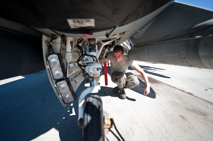 Airman 1st Class Aaron Hoffhines, a crew chief assigned to the 20th Aircraft Maintenance Squadron, Shaw Air Force Base, S.C., checks under an F-16 Fighting Falcon prior to a Red Flag 15-1 training sortie at Nellis Air Force Base, Nev., Feb. 10, 2015. Crew chiefs are responsible for and dedicated to a single aircraft, and have their name stenciled on the aircraft along with the pilot’s. (U.S. Air Force photo by Staff Sgt. Siuta B. Ika)