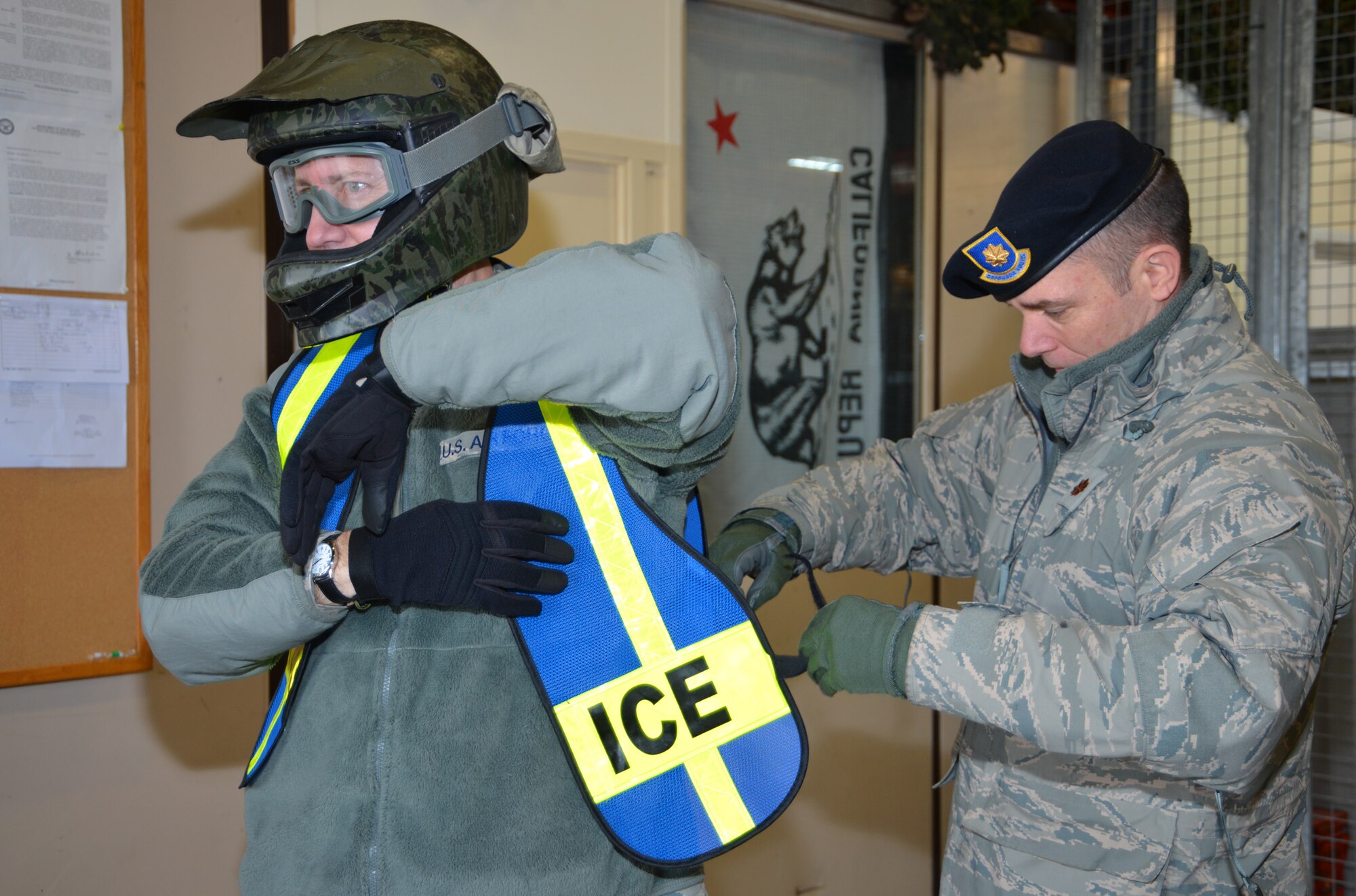 U.S. Air Force Maj. Jeffrey Adams, right, 100th Security Forces Squadron commander, assists U.S. Air Force Col. David Avila, 100th Mission Support Group commander, put on safety gear in preparation for riding an all-terrain vehicle Feb. 9, 2015, on RAF Mildenhall, England. Avila, along with U.S. Air Force Chief Master Sgt. Kathryn Aleshire, 100th MSG command chief, helped perform perimeter checks with two 100th SFS Defenders. In addition to learning more about the ATVs and their importance, the 100th MSG leadership helped check the structural integrity of the fence to ensure there was no damage. (U.S. Air Force photo by Karen Abeyasekere/Released)