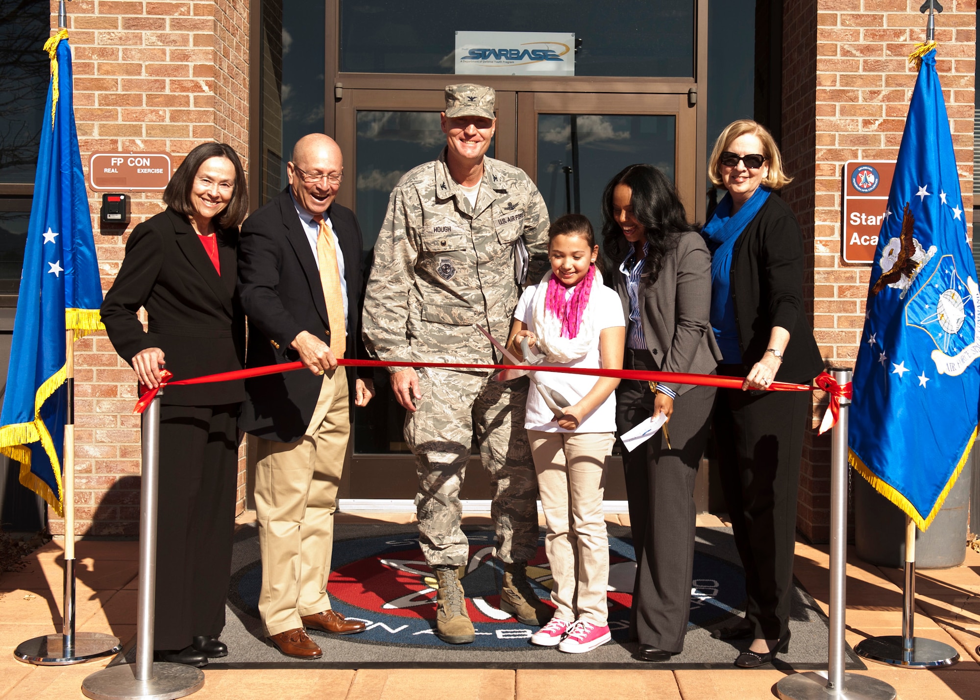 PETERSON AIR FORCE BASE, Colo. – Retired Air Force Gen. Gene Renuart, Jill Renuart, Col. Michael Hough, 21st Space Wing vice commander, Stephanie Molina, Yvaal Hampton, STARBASE director, and Barbara Koscak, STARBASE co-founder, cut the ribbon during the opening ceremony, Feb. 2, 2015. After years in the making, the facility will host 25-50 fifth grade students from local elementary schools for five-day programs, where they will learn various lessons in science, technology, engineering and mathematics. (U.S. Air Force photo by Senior Airman Tiffany DeNault)