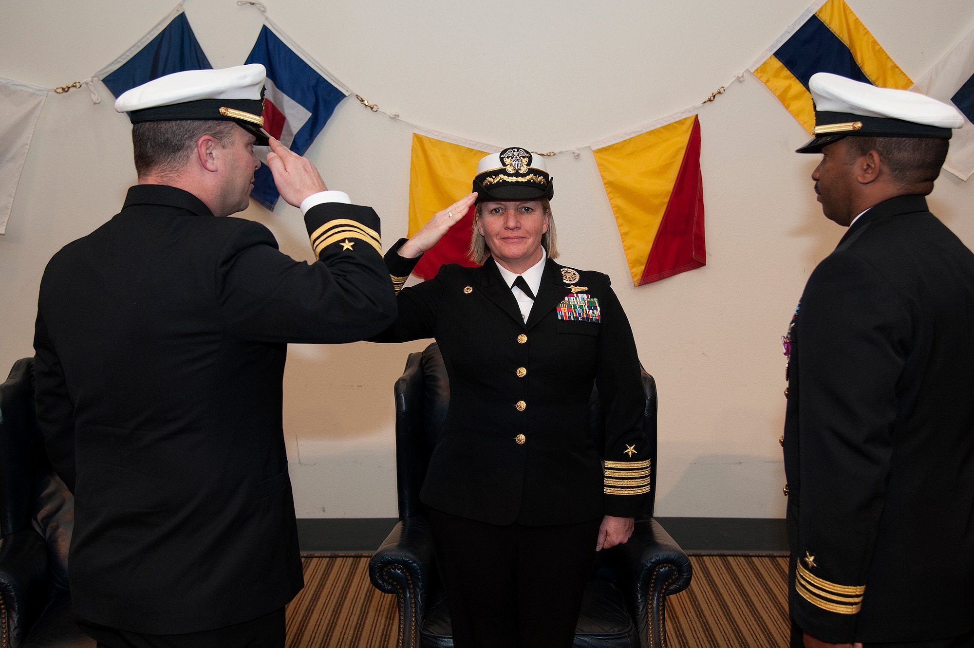 GOODFELLOW AIR FORCE BASE, Texas – U.S. Navy Lt. Cmdr. Chris M. Allen, left, assumes command of the Navy Center for Information Dominance Detachment from Lt. Cmdr. Cornell A. Woods, right, during the change of charge ceremony officiated by Capt. Maureen Fox, Center for Information Dominance Commander, at the Event Center Feb. 6. (U.S. Air Force photo/ Airman 1st Class Devin Boyer)