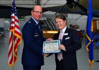Col. Raymond A. Kozak, 512th Airlift Wing commander, presents a certificate of induction to John Paradee, Baird, Mandalas & Brockstedt partner, as part of the Team Dover Honorary Commander Induction Ceremony Feb. 7, 2015, at the Air Mobility Command Museum. The Honorary Commander Program began in 1992 at Dover Air Force Base, Del.,to foster relationships between civic and military leaders. (U.S. Air Force photo/Airman 1st Class William Johnson)