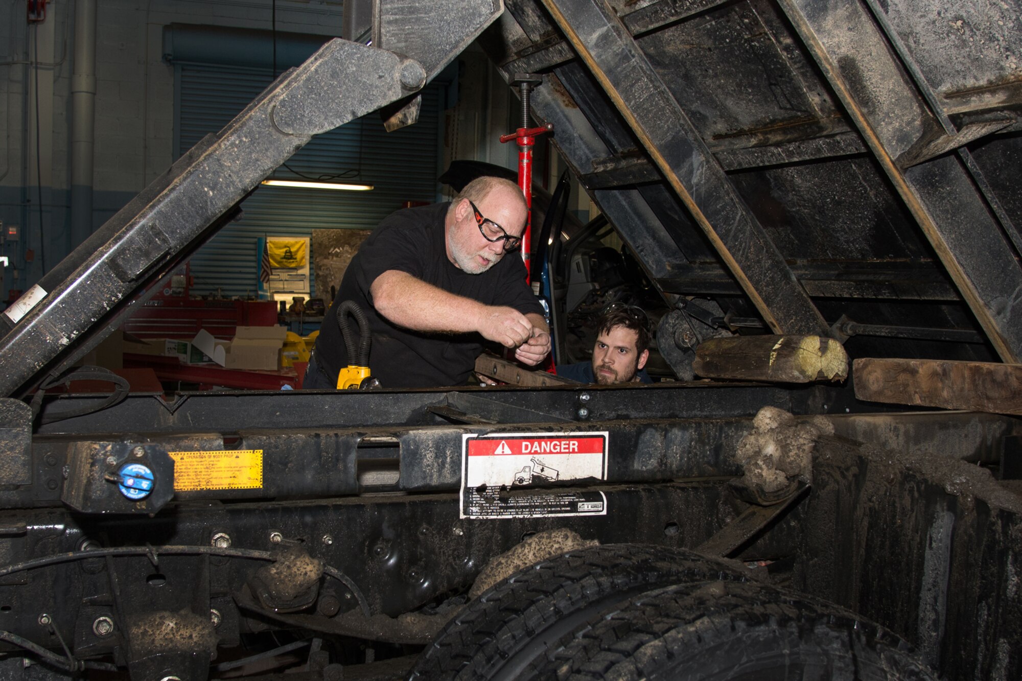 Rick Lord (left) and Stevan Blamer, 66th Logistics Readiness Squadron mechanics, repair snow removal equipment at the motor pool after the latest round of snow hit the region, Feb. 10. LRS mechanics have been working long shifts since Jan. 24 to ensure snow removal equipment is operating optimally and safely for snow removal operations. The mechanics sustain a wide variety of equipment, from large ten wheeled dump-trucks to six passenger 4 x 4 pick-up trucks both equipped with plow blades, and large four cubic yard front-end loaders to multi-purpose sidewalk cleaners. (U.S. Air Force photo by Mark Herlihy)