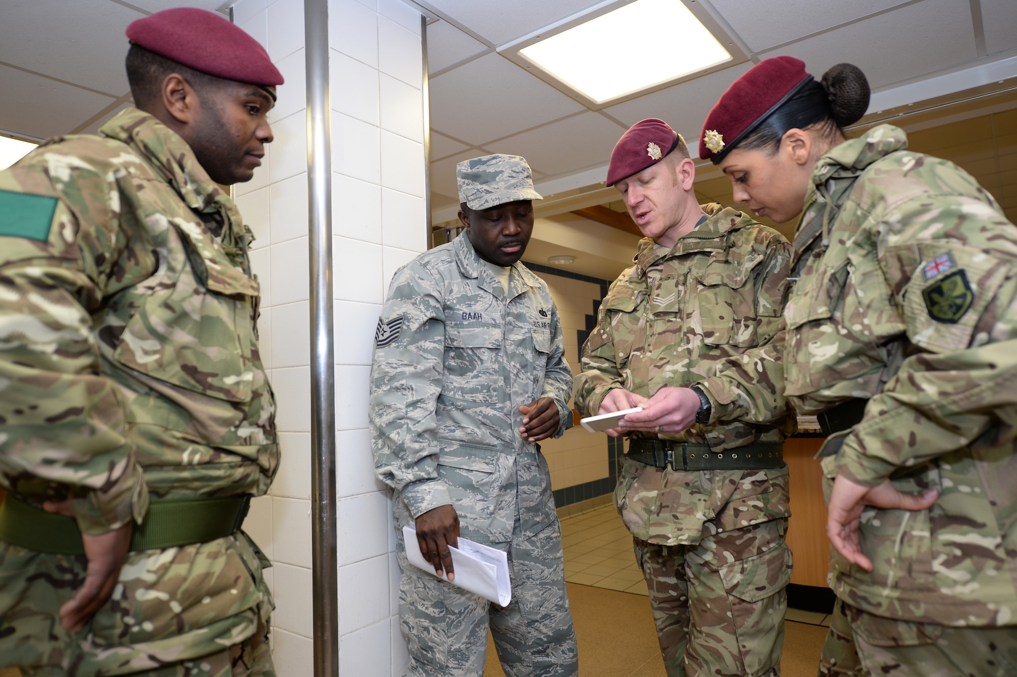 Tech. Sgt. Thomas Baah, 48th Force Support Squadron Knight's Table Dining Facility manager, answers questions from Royal Army cooks from 3rd Battalion, Parachute Regiment, Colchester garrison, about the dining facility at Royal Air Force Lakenheath, England, Jan. 3, 2015. RA cooks visited to gain knowledge and experience on how American forces cater dining facilities. (U.S. Air Force photo by Staff Sgt. Emerson Nuñez/Released)