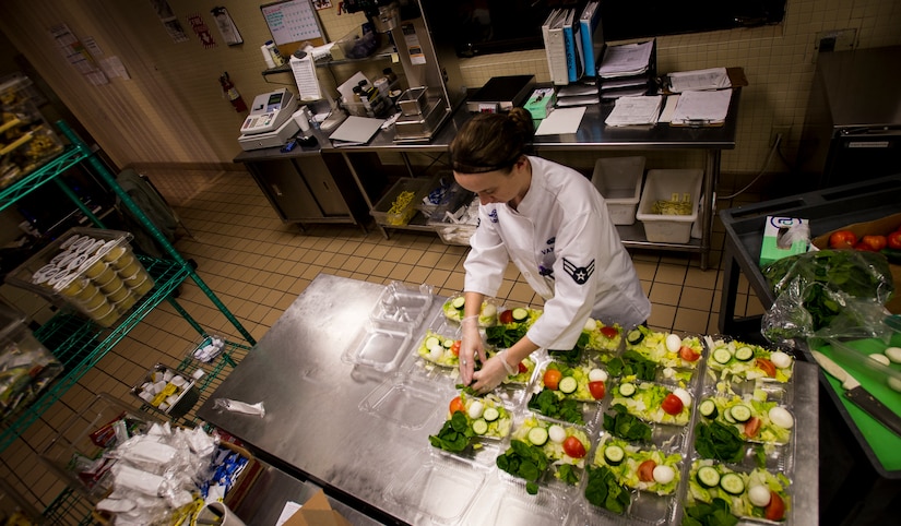 Airman 1st Class Carissa Vancise, 628th Force Support Squadron food service apprentice, prepares salads for large and small meals Feb. 10, 2015, at the flight kitchen on Joint Base Charleston, S.C. Vancise works 12 hour shifts throughout the night to provide ground support meals to base personnel to include aircrew, maintenance, and security forces, as well as passengers travelling on Space Available flights. Meal options consist of sandwiches, salads and breakfast items. (U.S. Air Force photo/Airman 1st Class Clayton Cupit)