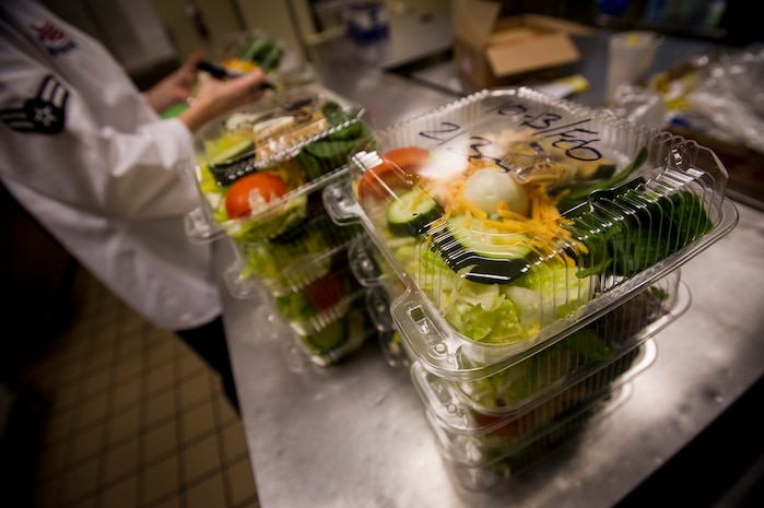 Finished salads pile up at the flight kitchen on Joint Base Charleston, S.C. Airman 1st Class Carissa Vancise, 628th Force Support Squadron food service apprentice, works 12-hour shifts through the night to provide ground support meals to base personnel to include aircrew, maintenance, and security forces; as well as to Space A passengers. (U.S. Air Force photo/Airman 1st Class Clayton Cupit)