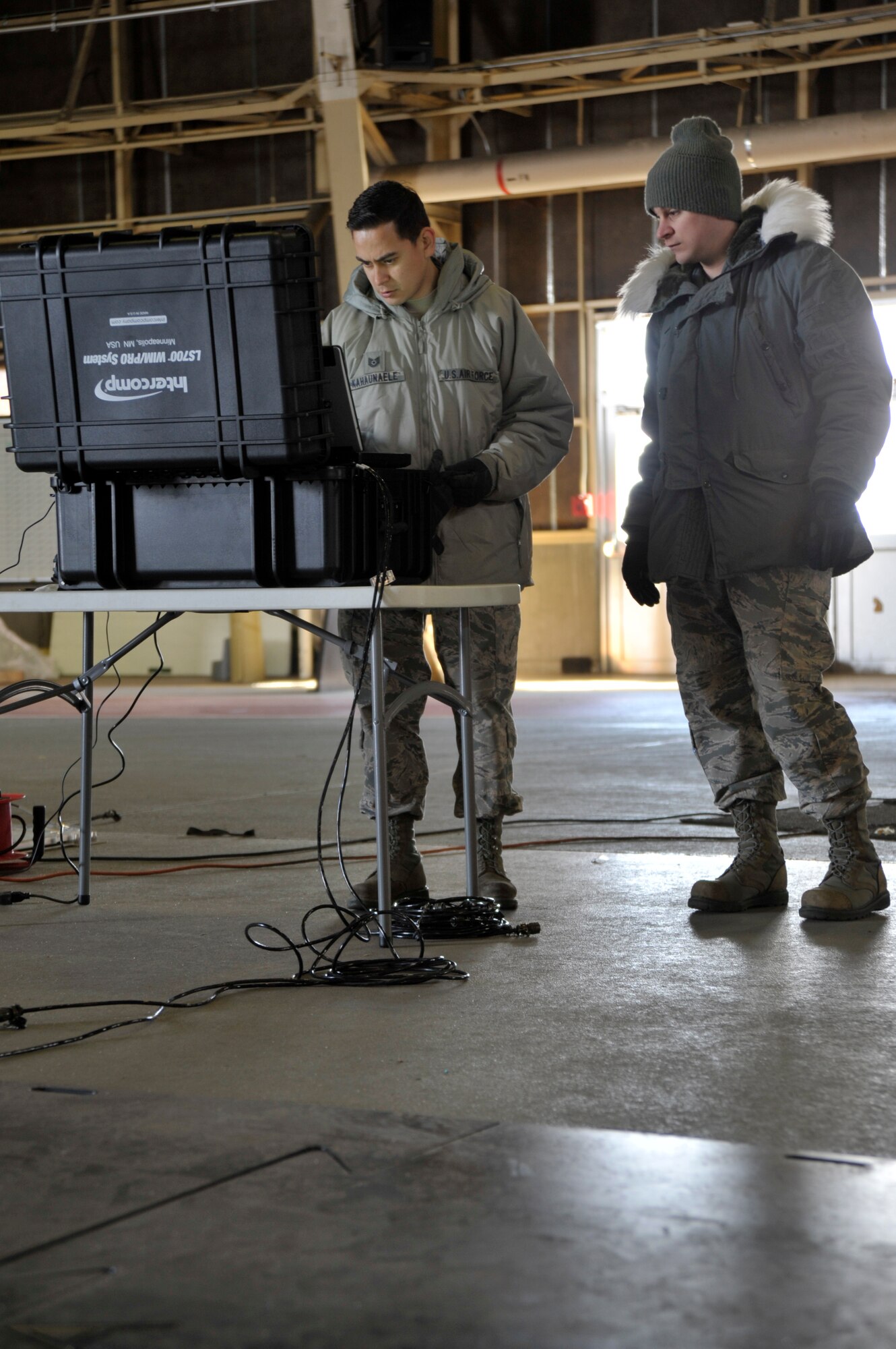 U.S. Air Force Tech. Sgt. Derek Kahaunaele and Senior Airman Eric Raber, 35th Logistics Readiness Squadron cargo movement specialists, check the settings on a portable Weigh In Motion system at Misawa Air Base, Japan, Feb. 9, 2015. The newly acquired portable WIM system has the ability to weigh both platform vehicle and cargo simultaneously, while differentiating between both. (U.S. Air Force photo by Senior Airman Jose L. Hernandez-Domitilo)