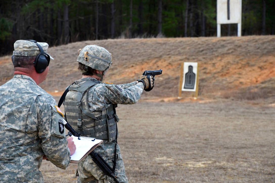 Army Sgt. Chelsie Sloan, right, fires an M9 Beretta pistol during the ...