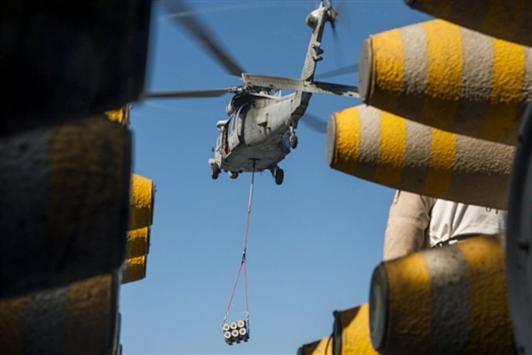 A Navy MH-60S Seahawk helicopter delivers a pallet of ordnance to the flight deck of the amphibious assault ship USS Essex in the Pacific Ocean, Feb. 9, 2015. The Essex is underway off the coast of California completing certifications in preparation for a 2015 deployment.