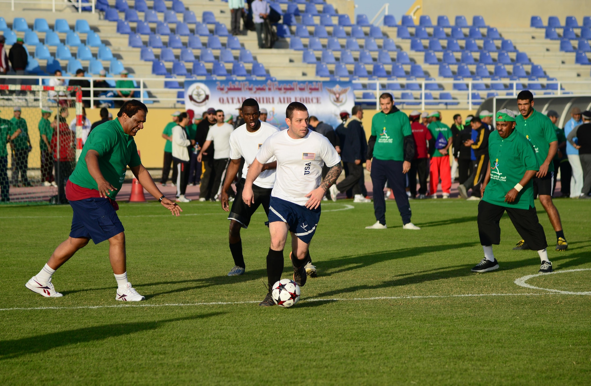 U.S. servicemembers and Qatar Emiri Air Force members play a friendly game of soccer during Qatar National Sports Day, Feb. 10, 2015, at Al Udeid Air Base, Qatar. More than 80servicemembers teamed up to form basketball, soccer and volleyball teams to compete with the Qatar Emiri Air Force during their sports day. (U.S. Air Force photo by Senior Airman Kia Atkins)
