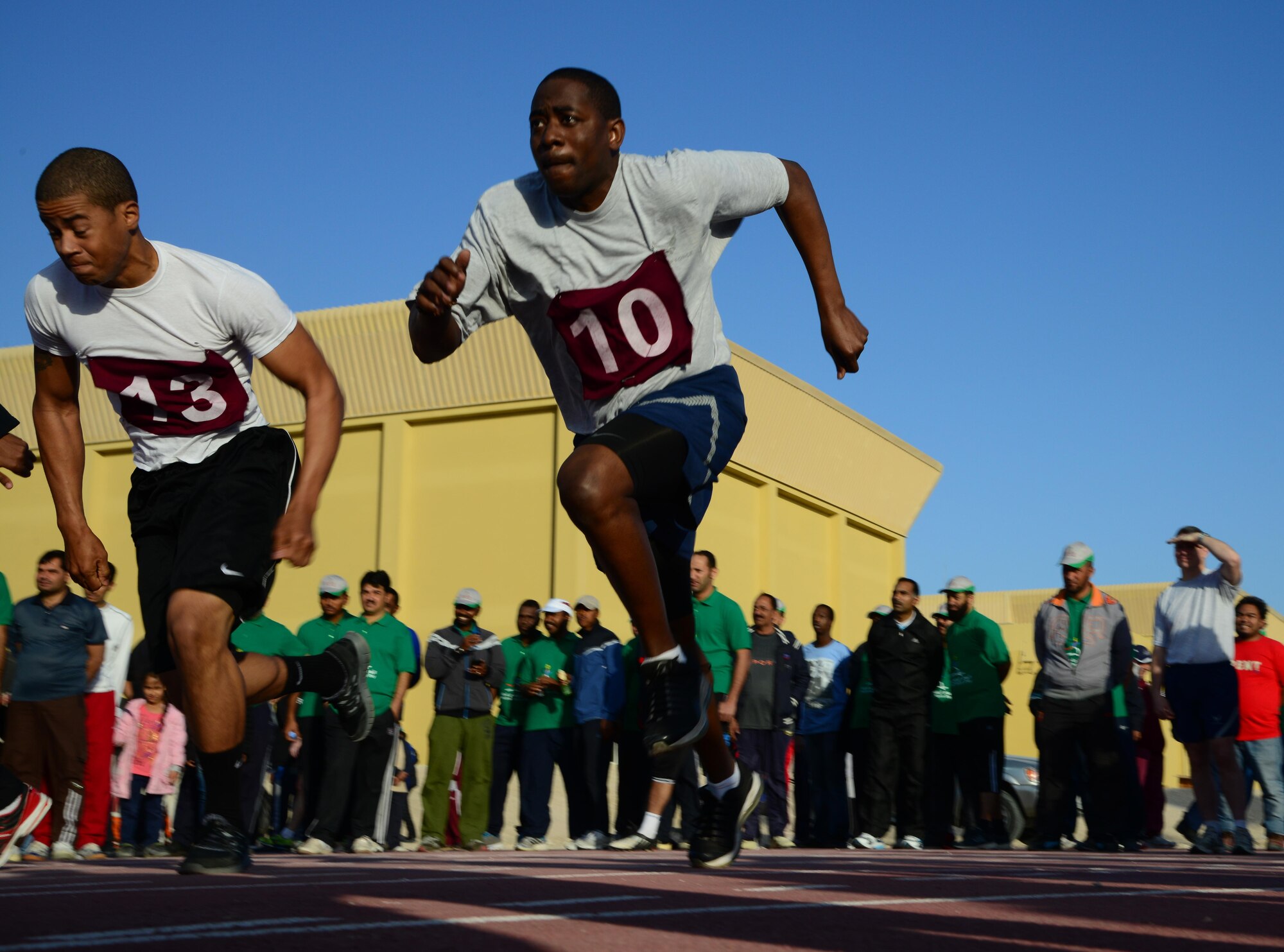 U.S. Air Force Tech. Sgt. Jason Copeland, 379th Air Expeditionary Wing Inspector General, right, competes in a 100m run during Qatar National Sports Day, Feb. 10, 2015, at Al Udeid Air Base, Qatar.  U.S. servicemembers and Qatar Emiri Air Force members participated in several events throughout the day such as volleyball, soccer and volleyball. There were also 150m, 400m and 1000m run events. (U.S. Air Force photo by Senior Airman Kia Atkins)