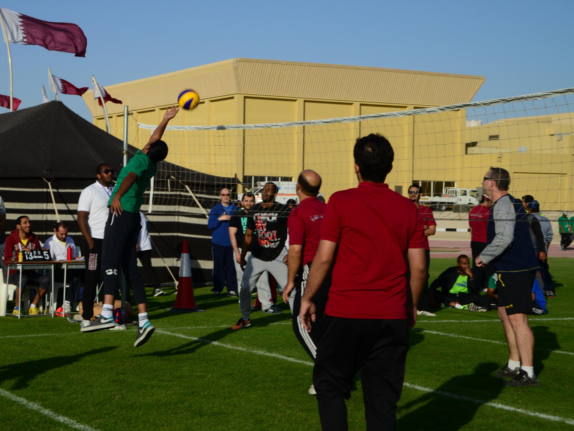 U.S. servicemembers and Qatar Emiri Air Force members play a game of volleyball during Qatar National Sports Day, Feb. 10, 2015, at Al Udeid Air Base, Qatar. The Qatar National Sports Day is an initiative adopted in 2011 by the current Emir, Sheikh Tamim bin Hamad Al Thani, to further embed sporting values into the nation's culture and inspire people to be healthy and engage in physical activities. (U.S. Air Force photo by Senior Airman Kia Atkins)
