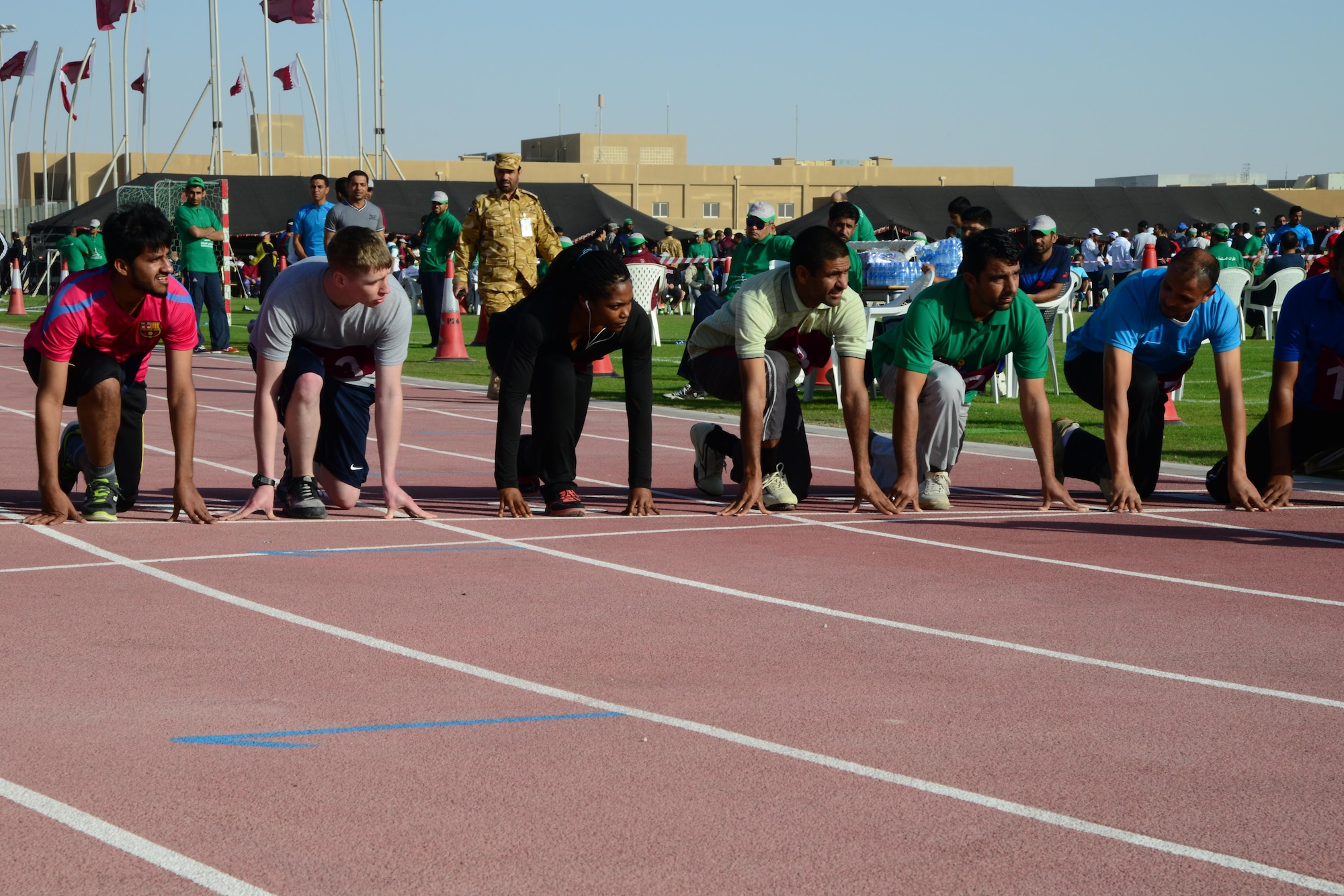 U.S. servicemembers and Qatar Emiri Air Force members line up before a 1000m run during Qatar National Sports Day, Feb. 10, 2015, at Al Udeid Air Base, Qatar. National Sports Day is a national holiday in Qatar, held annually since 2011 on the second Tuesday in February with the main objective being to promote a healthy lifestyle. (U.S. Air Force photo by Senior Airman Kia Atkins)