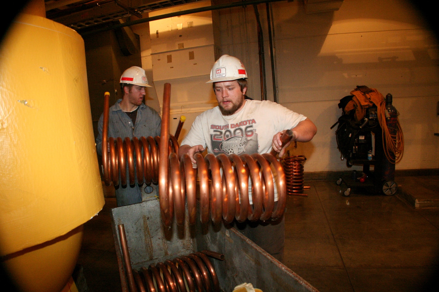 Electrician Connor Florey (left) asssists Mechanic Bryce Stasch (right) with new cooling coils to be installed on the hydropower units at Ft. Randall Dam.