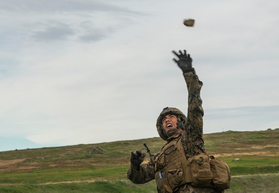 U.S. Marine Pfc. Joseph Aspiras throws a simulated grenade during squad tactics and maneuver training aboard Camp Pendleton, Calif., Jan. 26, 2015. Aspiras is a rifleman with Kilo Company, Battalion Landing Team 3rd Battalion, 1st Marine Regiment, 15th Marine Expeditionary Unit. As the ground combat element for the 15th MEU, BLT 3/1 is preparing for their upcoming deployment by enhancing their combat skills and learning to work as a cohesive unit. (U.S. Marine Corps Photo by Sgt. Emmanuel Ramos/Released)