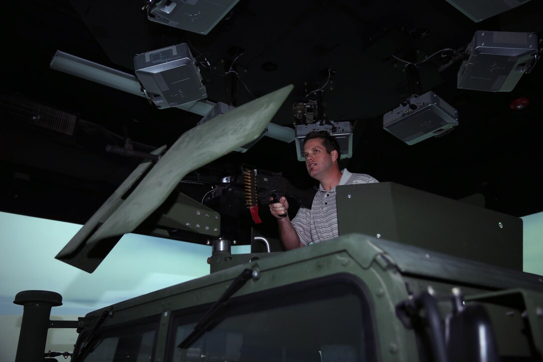Ryan Stendell, senior management analyst, City of Palm Desert, mans a simulated M240B Medium machine gun during a scenario inside the convoy simulator during a tour of the Combat Center, Jan. 28, 2015. City of Palm Desert officials attended a tour of the instillation in conjunction with their adoption of 7th Marine Regiment which included a live-fire portion using M4 service rifles. (Official Marine Corps Photo by Lance Cpl. Julio McGraw/Released)