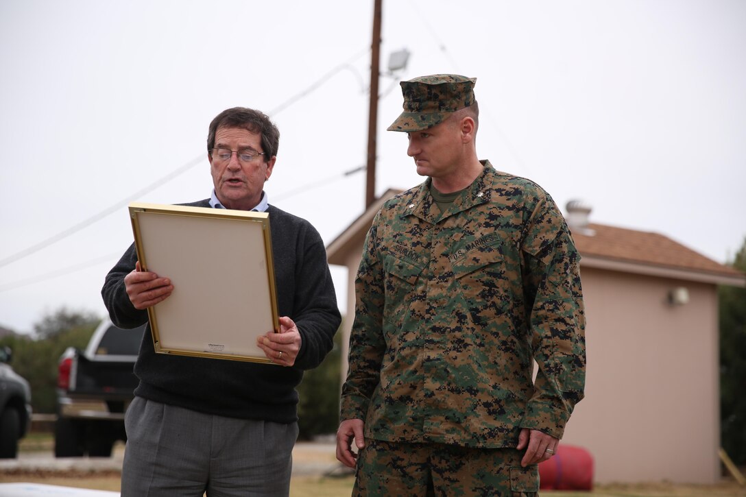 Van Tanner, former mayor, City of Palm Desert, presents Lt. Col. Jared Spurlock, executive officer, 7th Marine Regiment, with a framed certificate officially announcing the adoption of the unit by the City of Palm Desert during the city's tour of the Combat Center, Jan. 28, 2015. Spurlock accepted the certificate on behalf of Col. Jay Bargeron, commanding officer, 7th Marine Regiment. (Official Marine Corps Photo by Lance Cpl. Julio McGraw/Released)