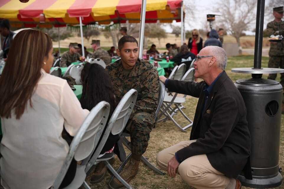 Sabby Jonathan, councilmember, City of Palm Desert, introduces himself to Pfc. Rodolfo Perez, field radio wireman, 7th Marine regiment, native of Houston, and Perez’s family during the family day portion of the city’s tour of the Combat Center at Desert Winds Golf Course, Jan. 28, 2015. (Official Marine Corps Photo by Lance Cpl. Julio McGraw)
