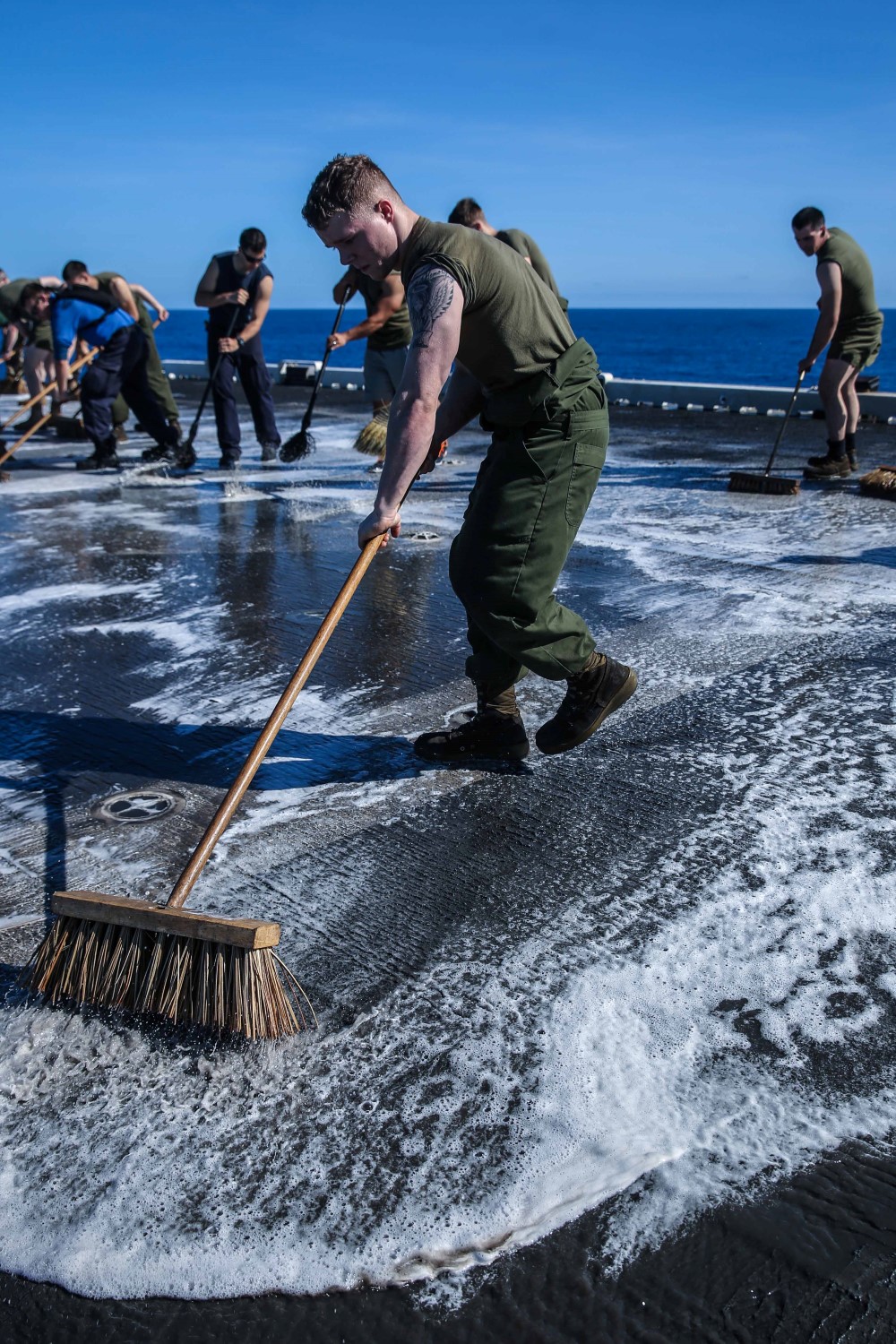 A Marine with Marine Medium Tiltrotor Squadron 163 (Reinforced), 11th Marine Expeditionary Unit, scrubs the flight deck of the amphibious assault ship USS Makin Island (LHD 8), Feb. 8. The 11th MEU and Makin Island Amphibious Ready Group are deployed to the U.S. 7th Fleet area of responsibility as a sea based, expeditionary crisis response force capable of conducting amphibious missions across the full range of military operations. (U.S. Marine Corps photo by Cpl. Evan R. White/Released)
