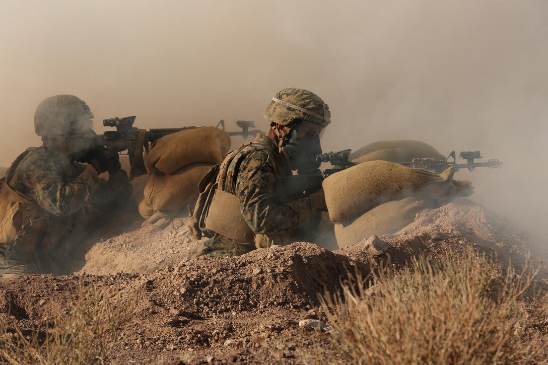 Pfc. Vincent Adames, native of San Antonio, and Pfc. William Estrada, native of Fontana, Calif., riflemen, Company I, 3rd Battalion, 7th Marine Regiment, watch their sectors of fire during an attack with 2-Chlorobenzalmalononitrile, also known as CS Gas, during the Marine Corps Combat Readiness Evaluation Exercise, Jan.15, 2015. The exercise tested the defensive response of 3/7 while tear gas engulfed the area. (Official Marine Corps Photo by. Lance Cpl. Julio McGraw/Released)