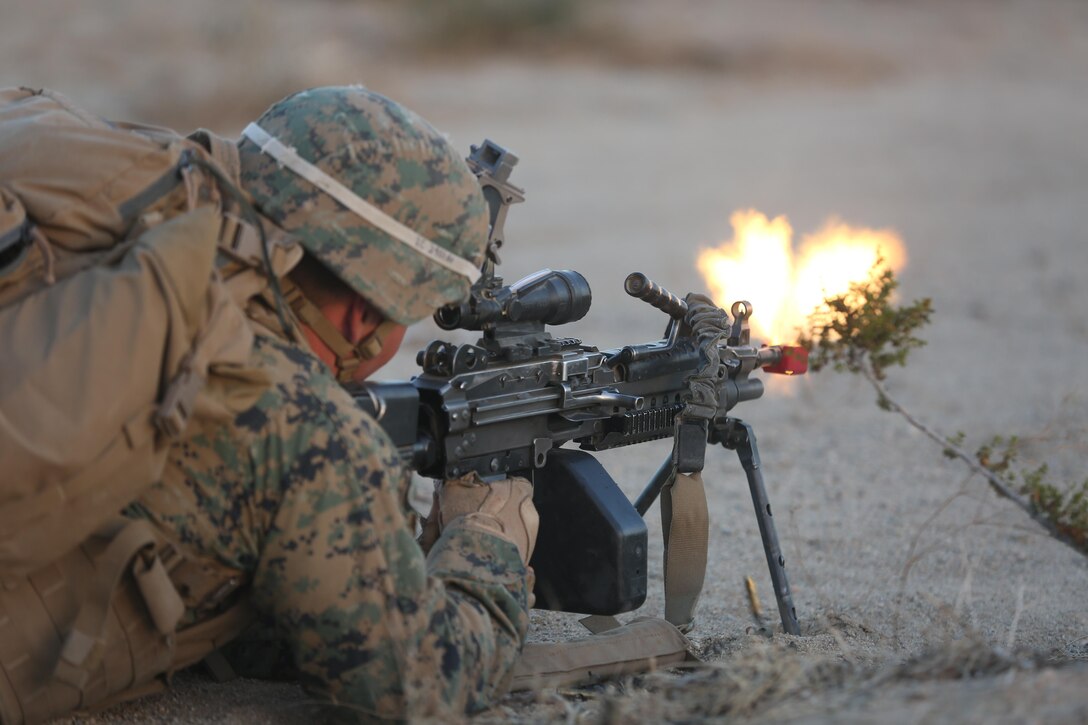 Lance Cpl. Michael Caliendo, rifleman, Company I, 3rd Battalion, 7th Marine Regiment, a native of Neptune City, N.J., fires blank rounds from an M249 Squad Automatic Weapon during an air-assault on a Military Operation on Urbanized Terrain town during a Marine Corps Combat Readiness Evaluation Exercise aboard the Combat Center, Jan. 16, 2015. (Official Marine Corps Photo by Lance Cpl. Julio McGraw/ Released)