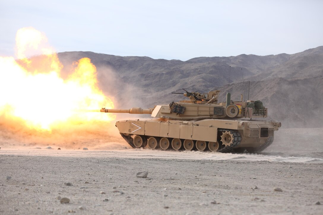 An M1A1 Abrams Tank from 1st Tank Battalion, Company B, fires its 120 mm main gun toward a target 1200 meters away during an assault on a Military Operation in Urban Terrain town on Range 210 during the Marine Corps Combat Readiness Evaluation Exercise, Jan. 20, 2015. ‘1st Tanks’ and 3rd Assault Amphibian Battalion supported 3rd Battalion, 7th Marine Regiment during their assault of the MOUT. (Official Marine Corps Photo by Lance Cpl. Julio McGraw/Released)